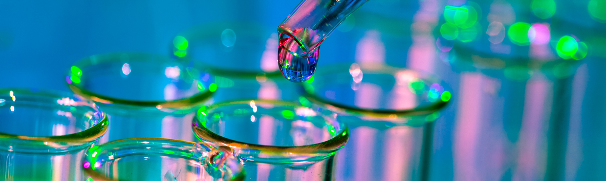 glass pipette transferring liquid to vials in laboratory